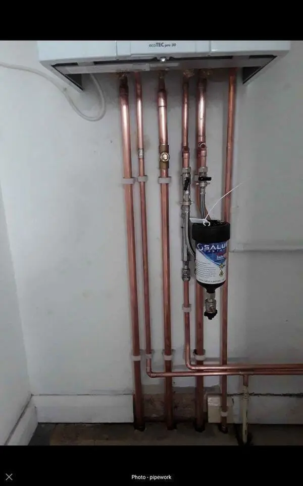 Professional copper pipework with magnetic system filter beneath Vaillant boiler