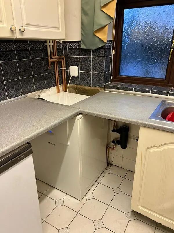 Floor-standing boiler installation in kitchen with smart thermostat