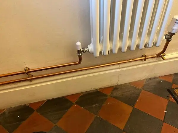 Traditional column radiator with copper pipework and TRV valves