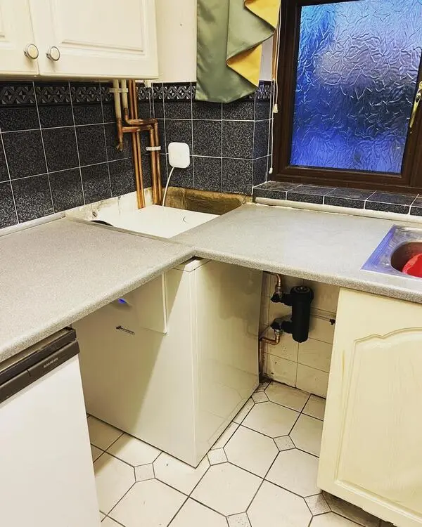 Floor-standing boiler installation in kitchen with smart thermostat controls