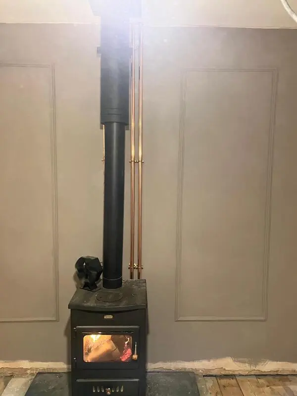 Wood burning stove installation with copper pipe back boiler connection